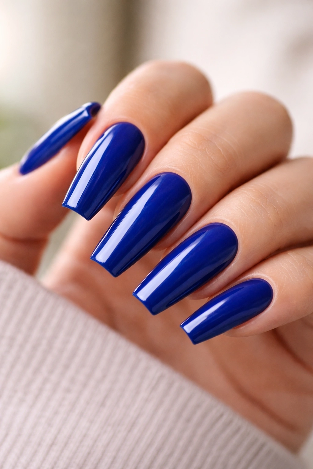 Close-up of blue coffin nails with squared tips and glossy finish