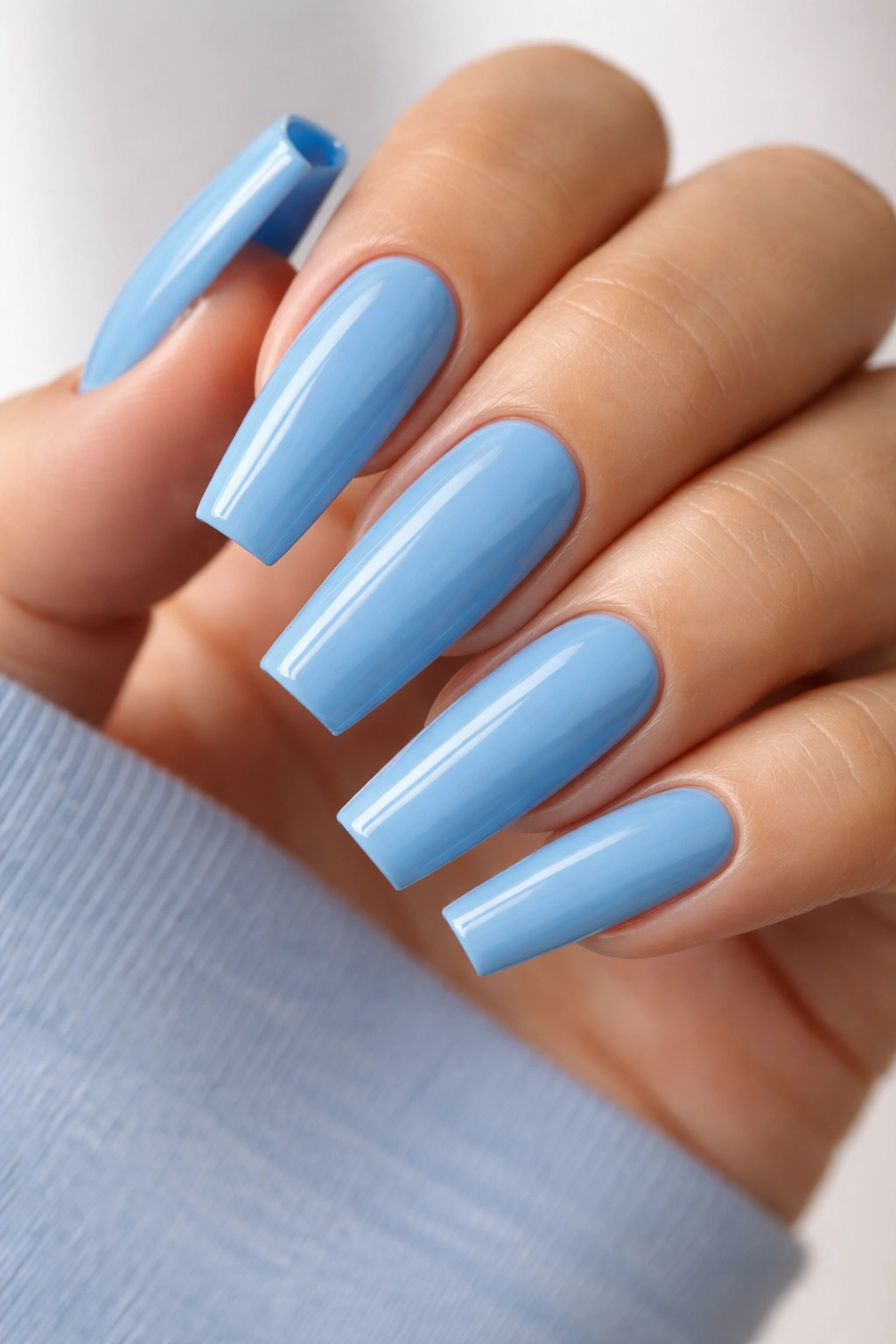 Close-up of blue coffin nails showing precise shaping and neat cuticles.
