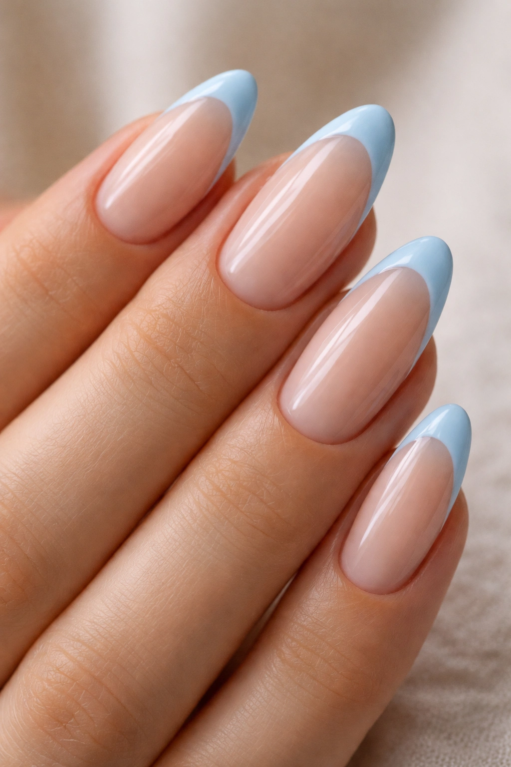 Almond nails with baby blue French tips on nude base