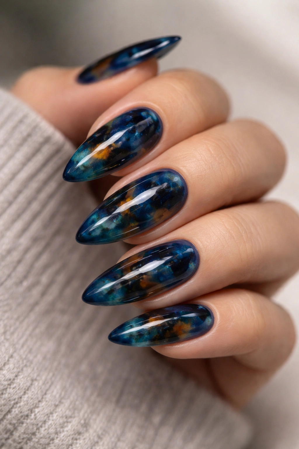 Blue tortoiseshell almond nails with translucent jelly finish close-up