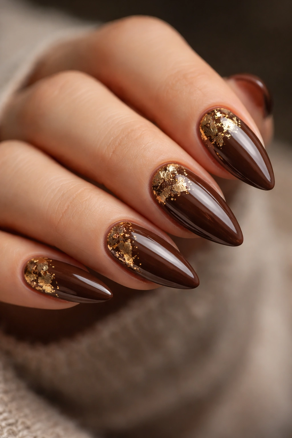 Almond nails with brown base and gold foil accents