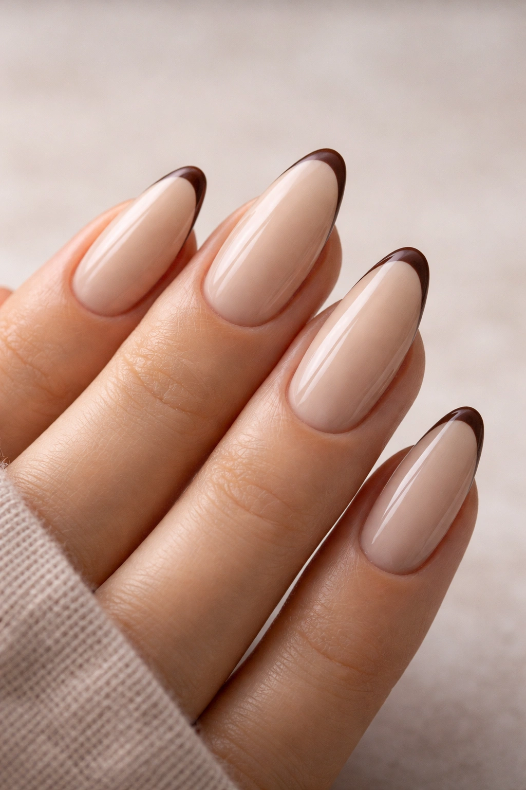Beige almond nails with slim brown French tips
