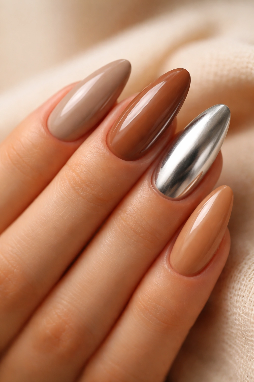 Almond nails in brown neutrals with chrome accent nail