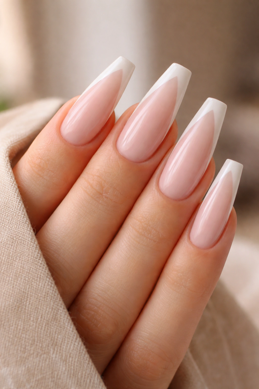 Close-up of bubble bath coffin nails with soft white side tips on a nude milky pink base