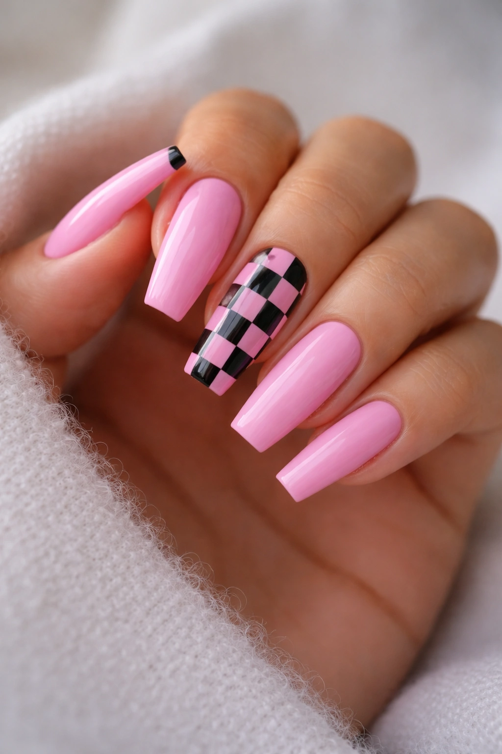 Close-up of bubblegum pink coffin nails with black-and-pink checkerboard accents on accent nails