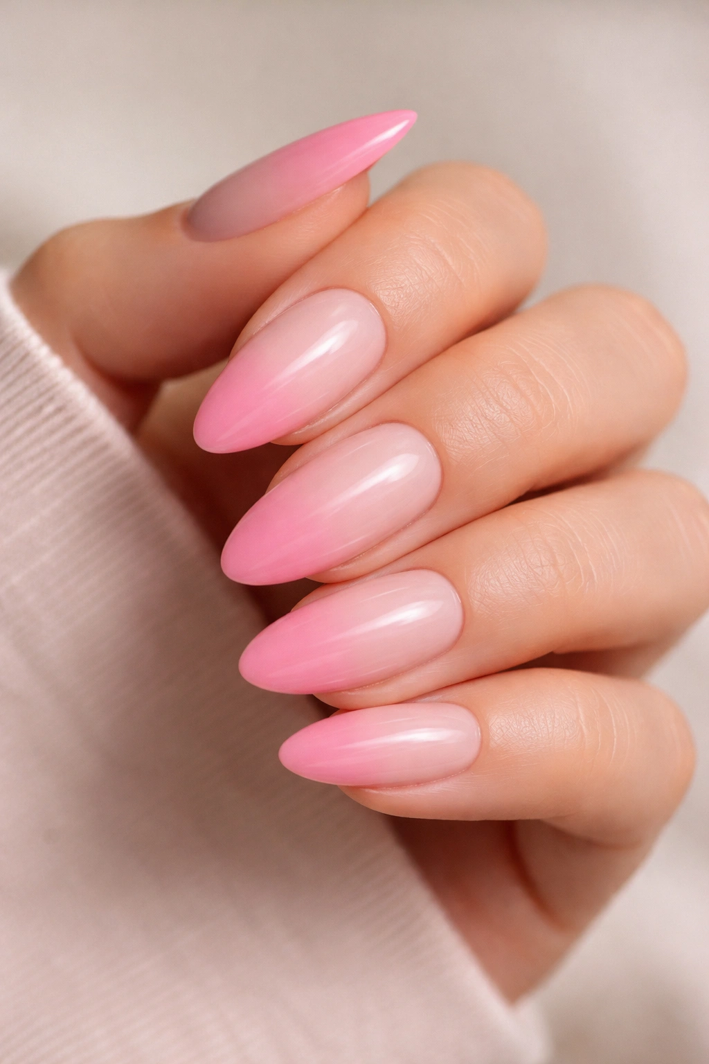Almond nails with a soft French fade from sheer base to bubblegum pink tip