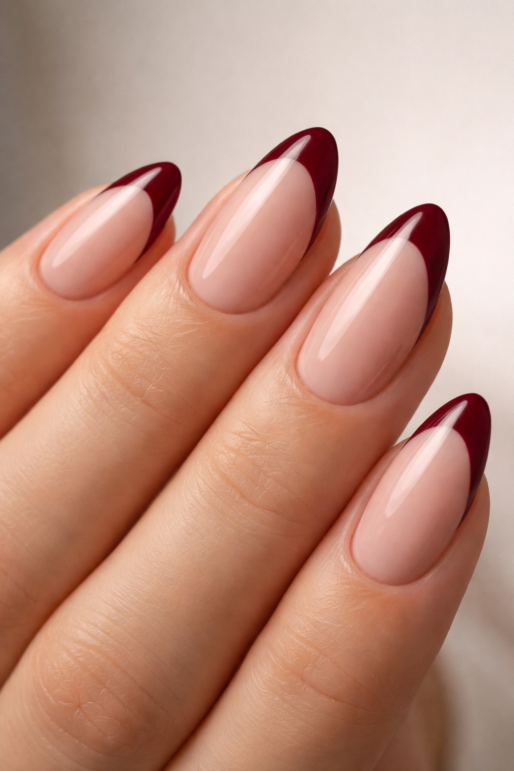 Nail close-up burgundy French tips on sheer nude base