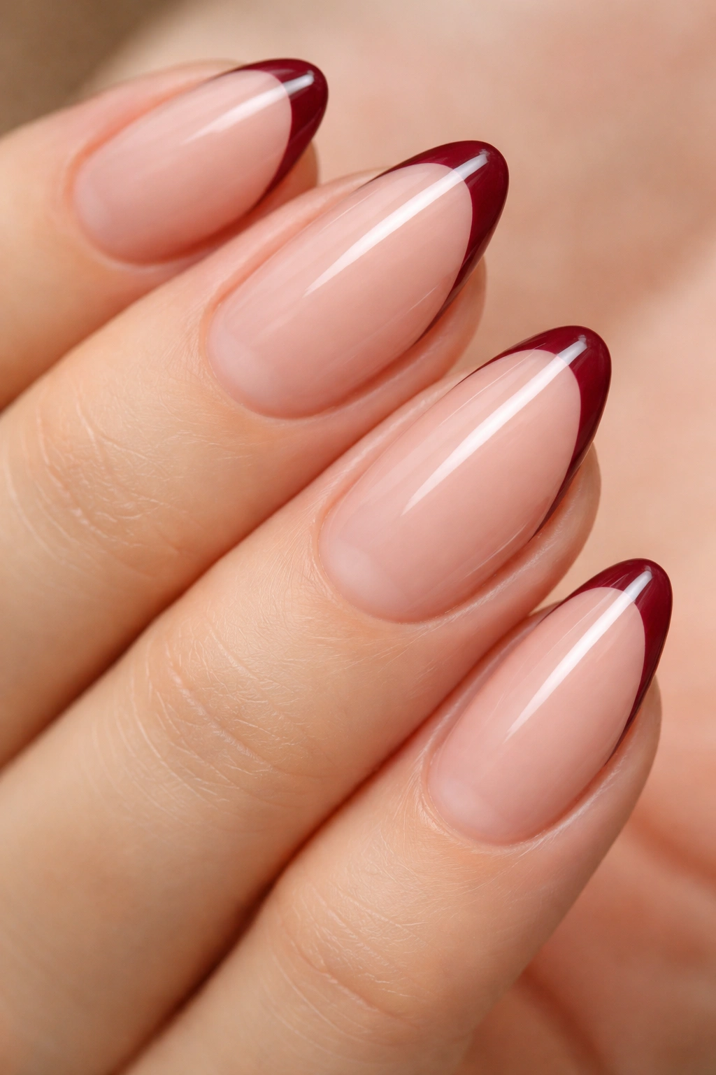 Close-up of burgundy micro-French almond nails with thin burgundy tips