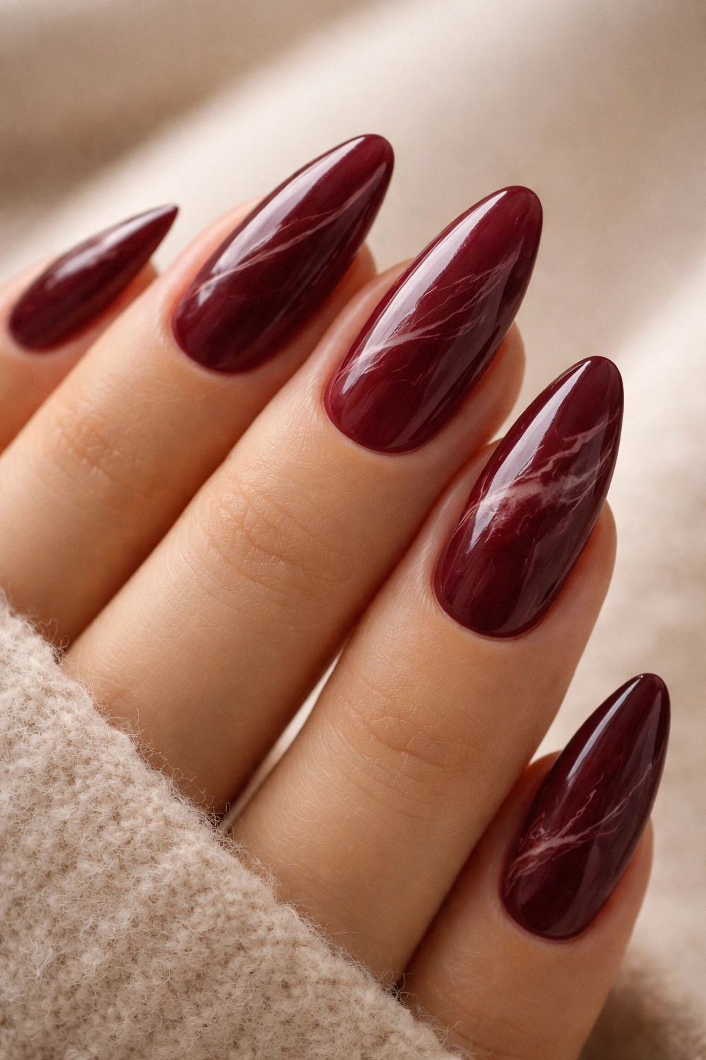 Almond nails with burgundy marble and fine veining