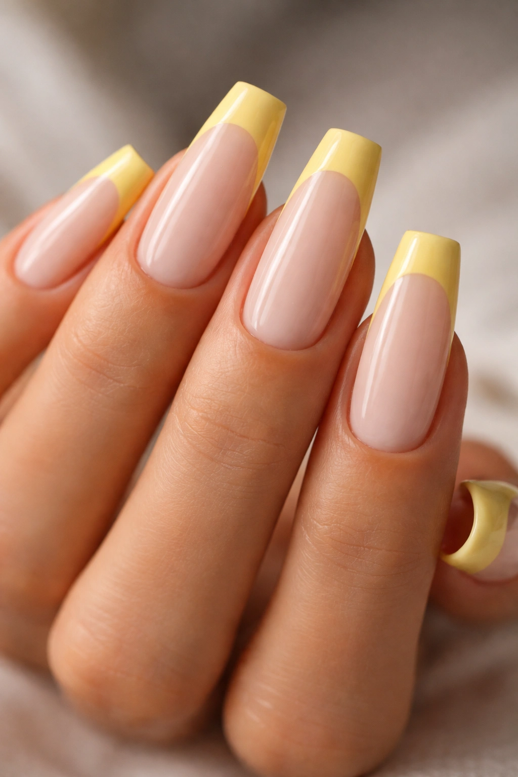 Coffin nails with butter yellow floating tips and a bare nude gap on a milky base.
