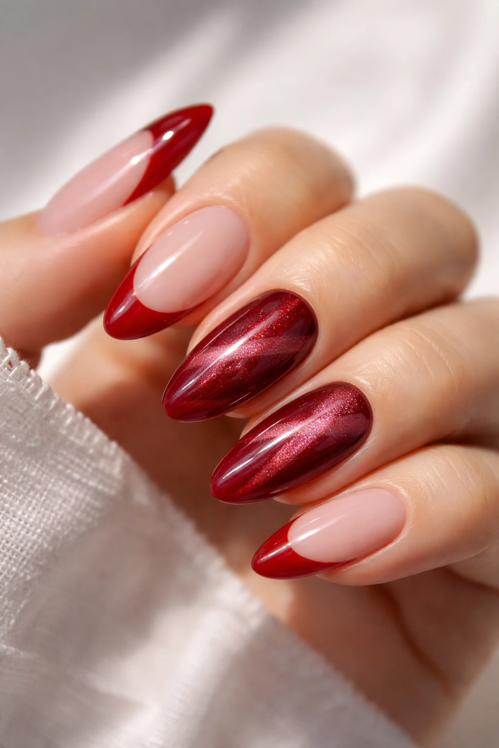 Almond nails with cherry red tips and cat-eye accent nails