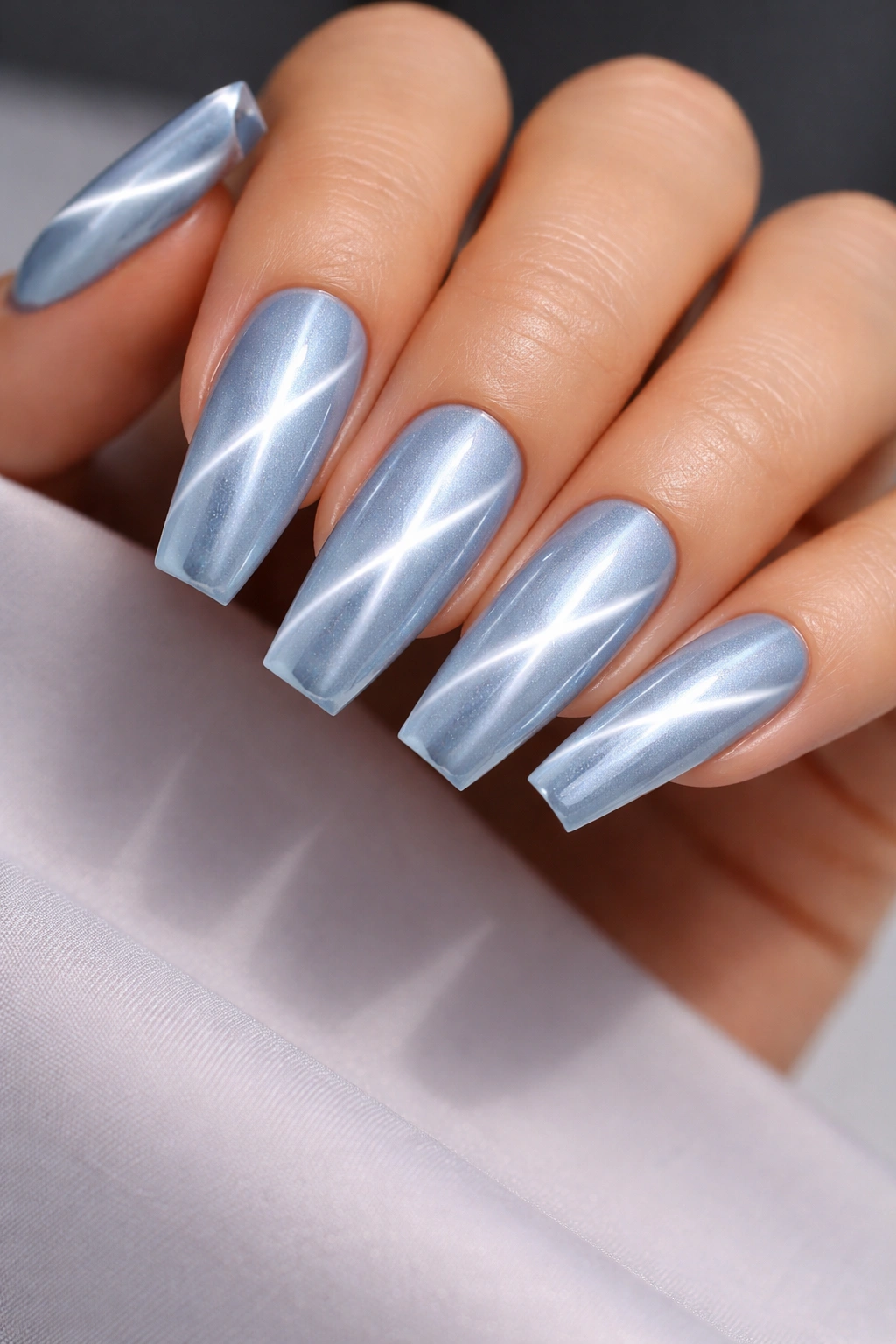 Close-up of cat-eye blue chrome coffin nails with a diagonal flash
