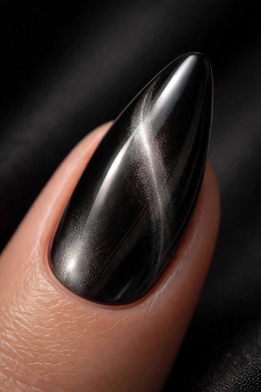 Close-up of a cat-eye black chrome almond nail with diagonal light stripe