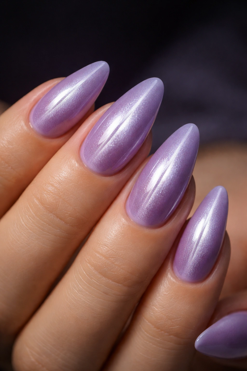 Close-up of cat-eye lavender nails showing a centered silver beam along almond nails