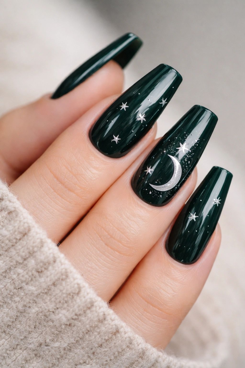 Close-up of dark green coffin nails with silver stars and a crescent moon