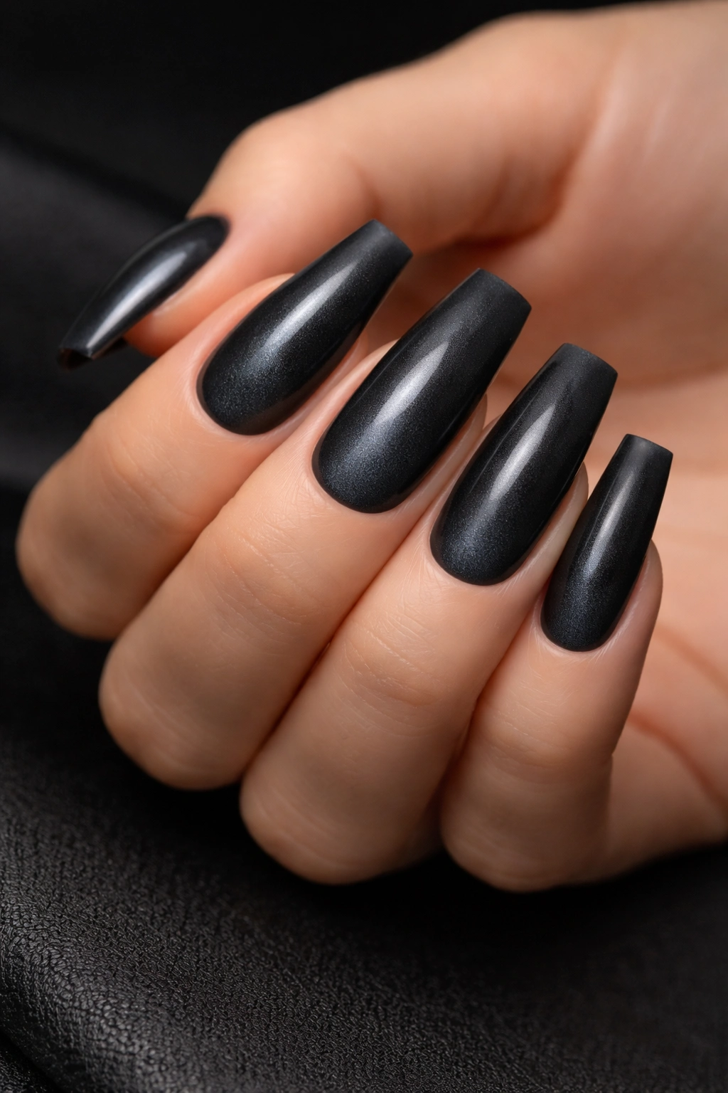 Close-up of charcoal cat eye nails with matte frame.