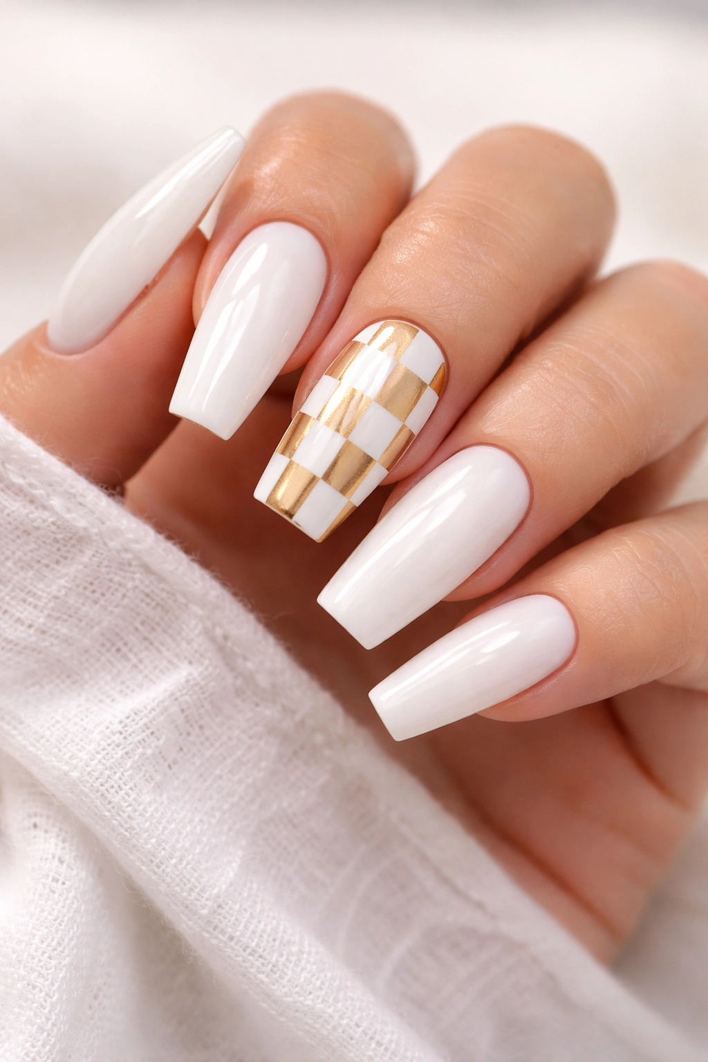 Close-up of white and gold checker accent coffin nails