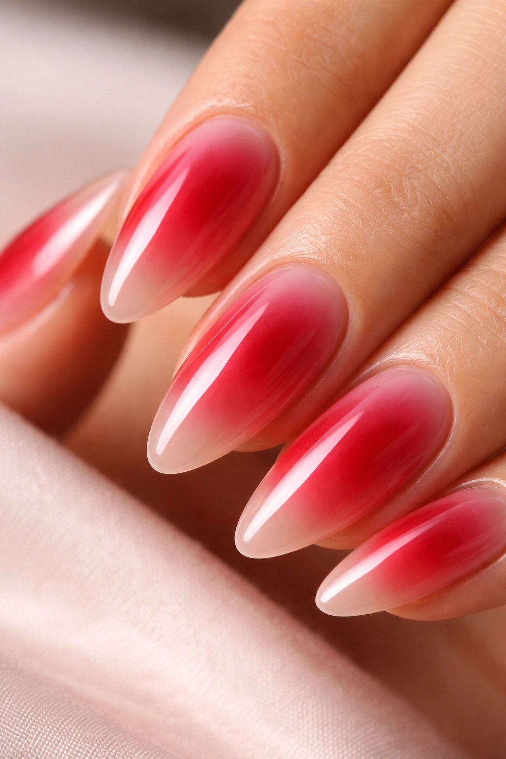 Almond nails with cherry jelly center featuring a jelly red glow over nude edges