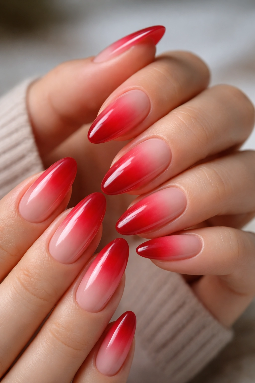 Close-up of almond nails with cherry red aura gradient and soft edge fade