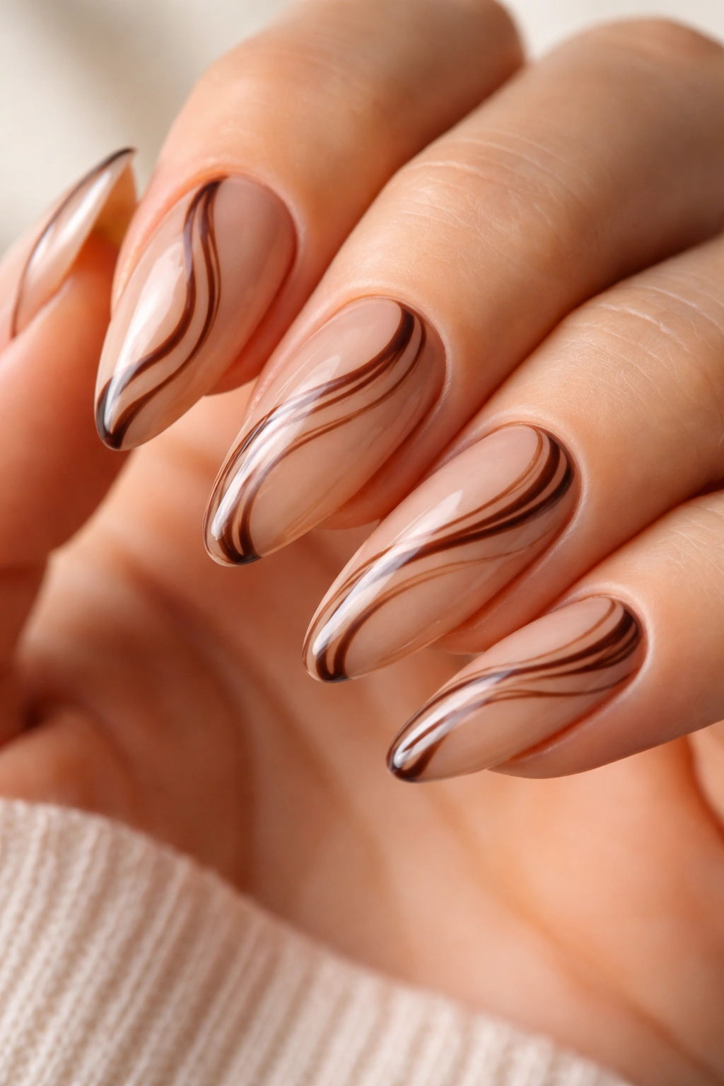 Almond nails featuring chocolate swirl latte on a sheer base