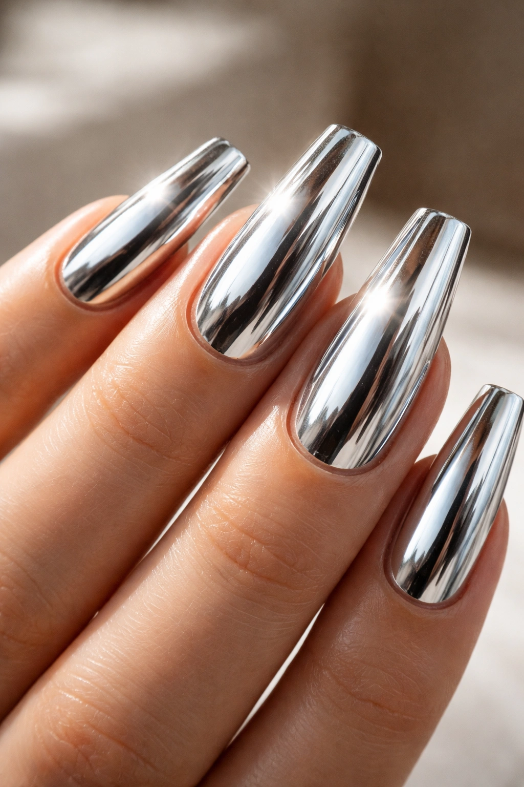 Close-up of chrome coffin nails with mirror-like shine and crisp sidewalls