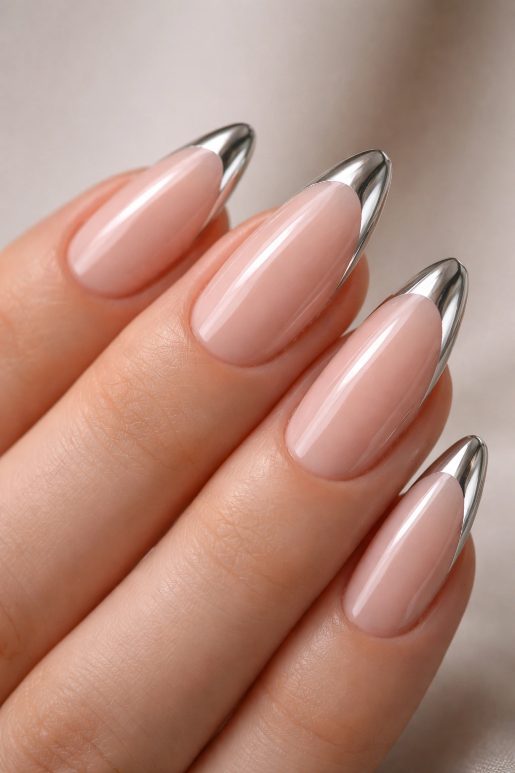 Almond nails with a slim chrome tip on a sheer pink base