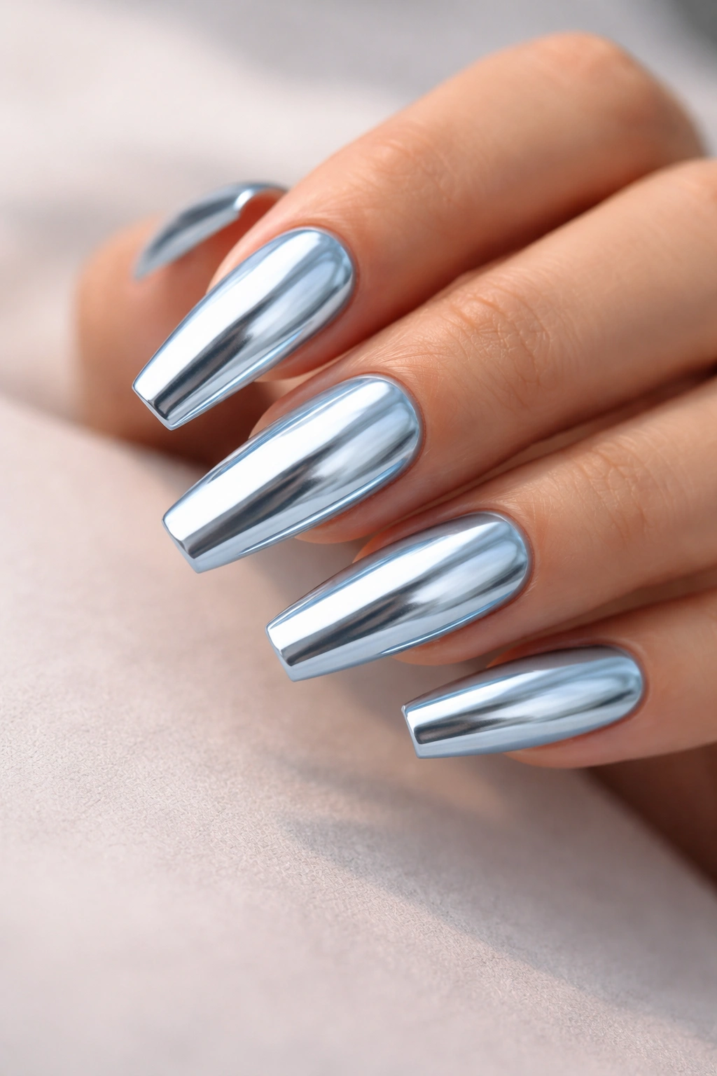 Close-up of Classic Mirror Light Blue Chrome Coffin Nails with a mirror finish on a hand