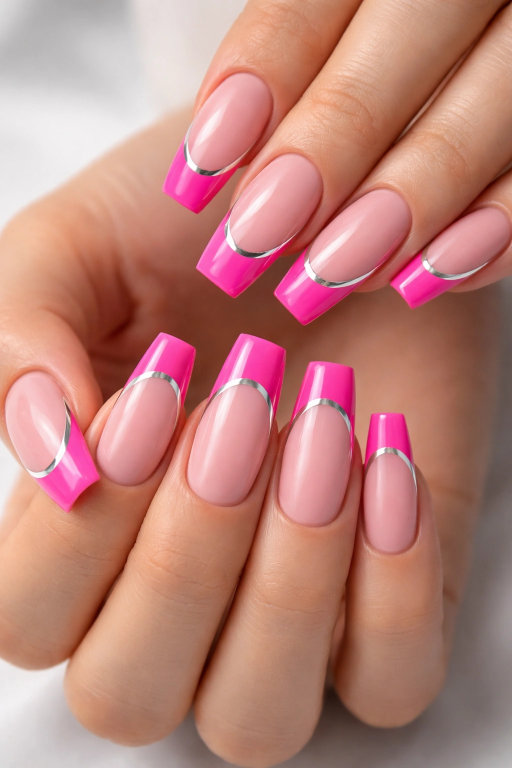 Hot pink French tips with a silver chrome stripe on coffin nails