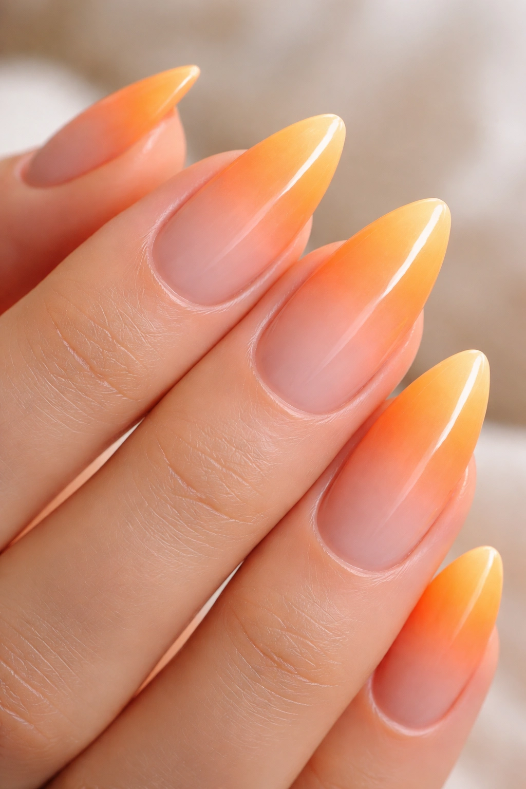 Close-up of citrus ombré almond nails showing smooth peach to orange gradient