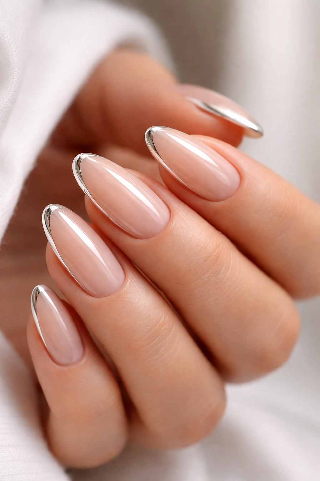 Almond nails with chrome accents on nude base.