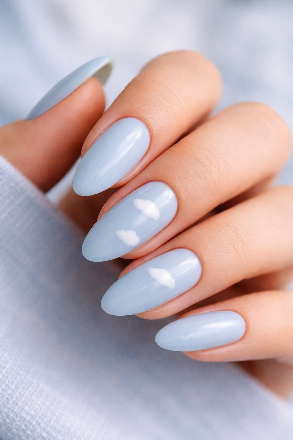 Tiny cloud art on soft blue almond nails