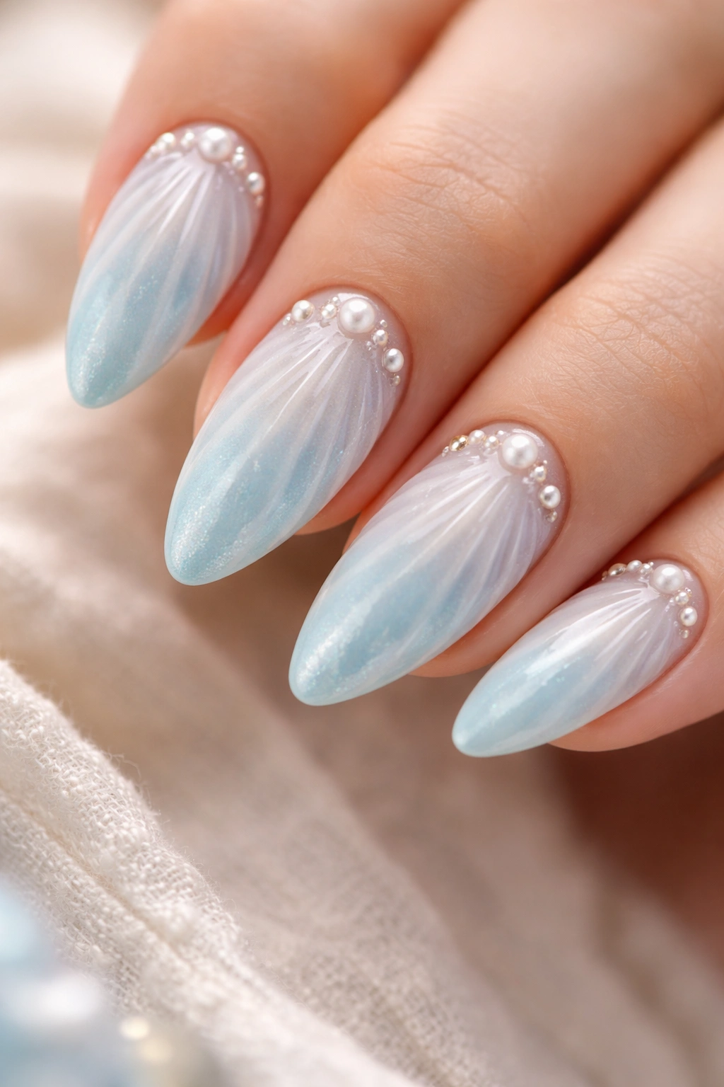 Close-up of Coastal Blue Shell Nails on almond-shaped nails with shell texture and pearl accents