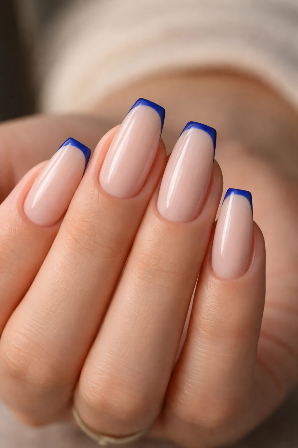 Close-up of cobalt micro-French nails on milky nude base