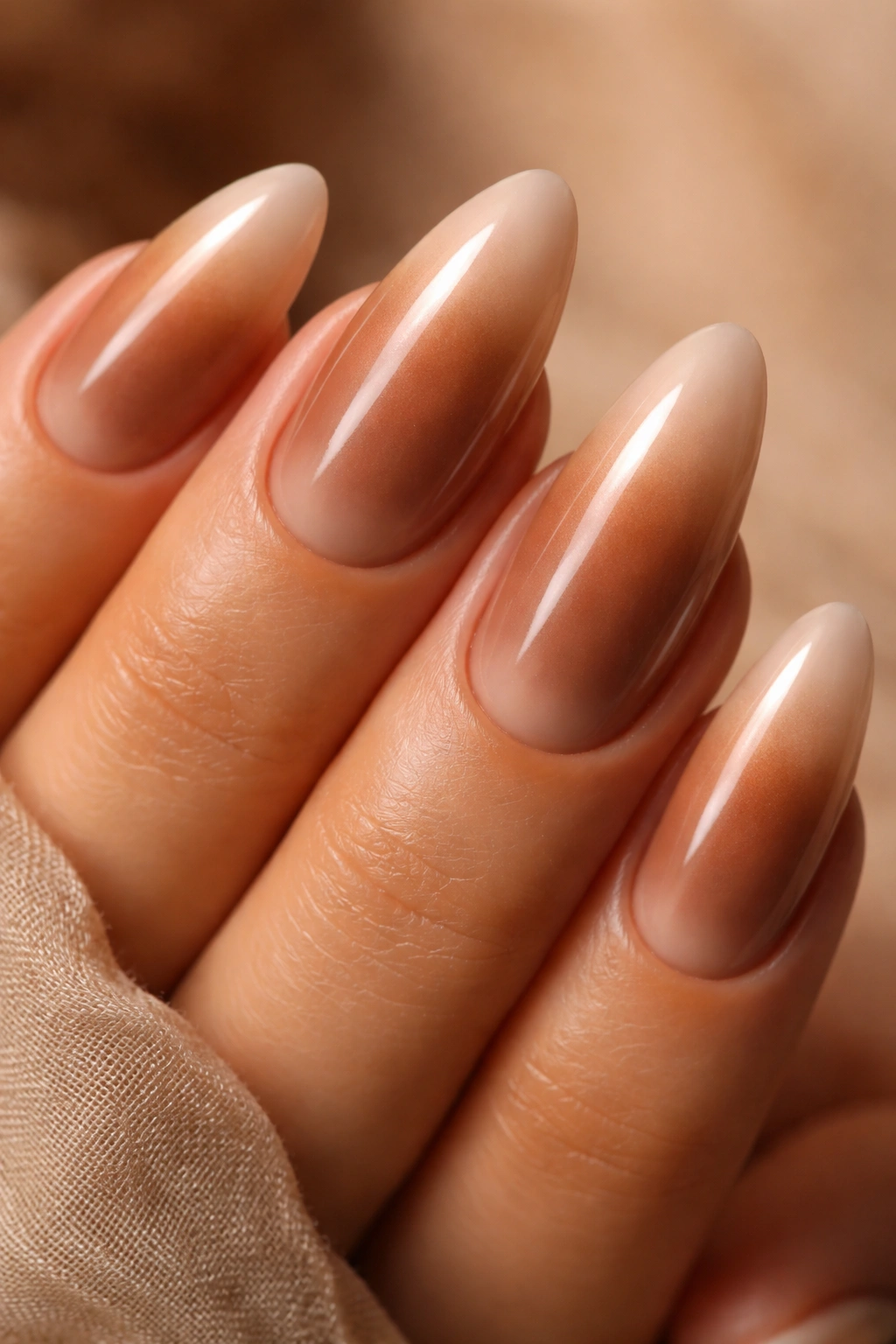 Almond nail with cocoa center fading to beige edge and warm glaze.
