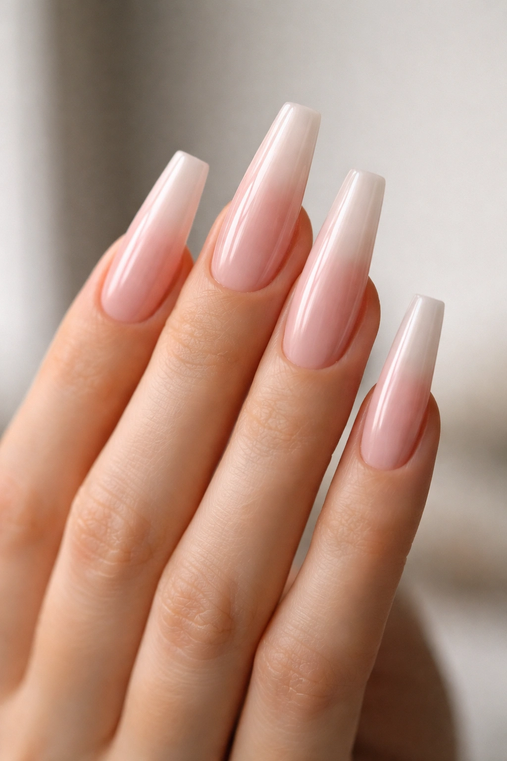 Close-up of long coffin nails with extra length and crisp edges on a bare hand