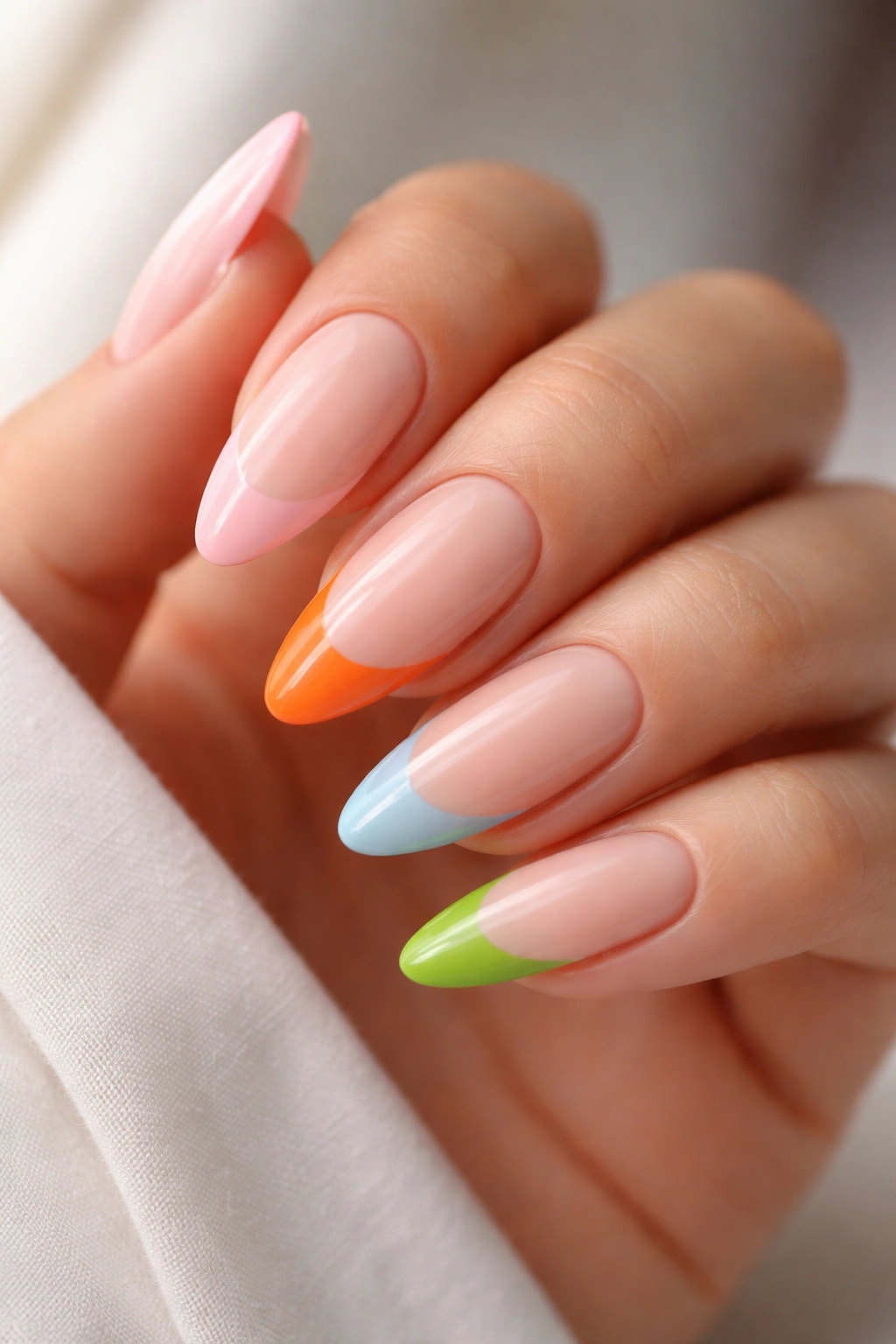 Close-up of almond nails with varied color-block tips on a single base