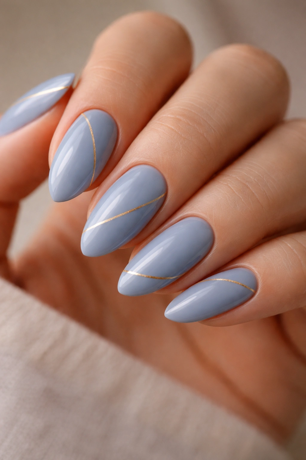 Almond nails in cornflower blue with a thin gold line accent