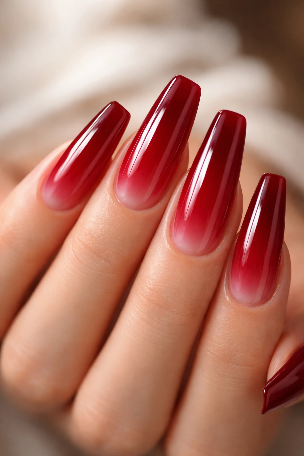 Close-up of coffin nails in a sheer cranberry jelly red with translucent finish.
