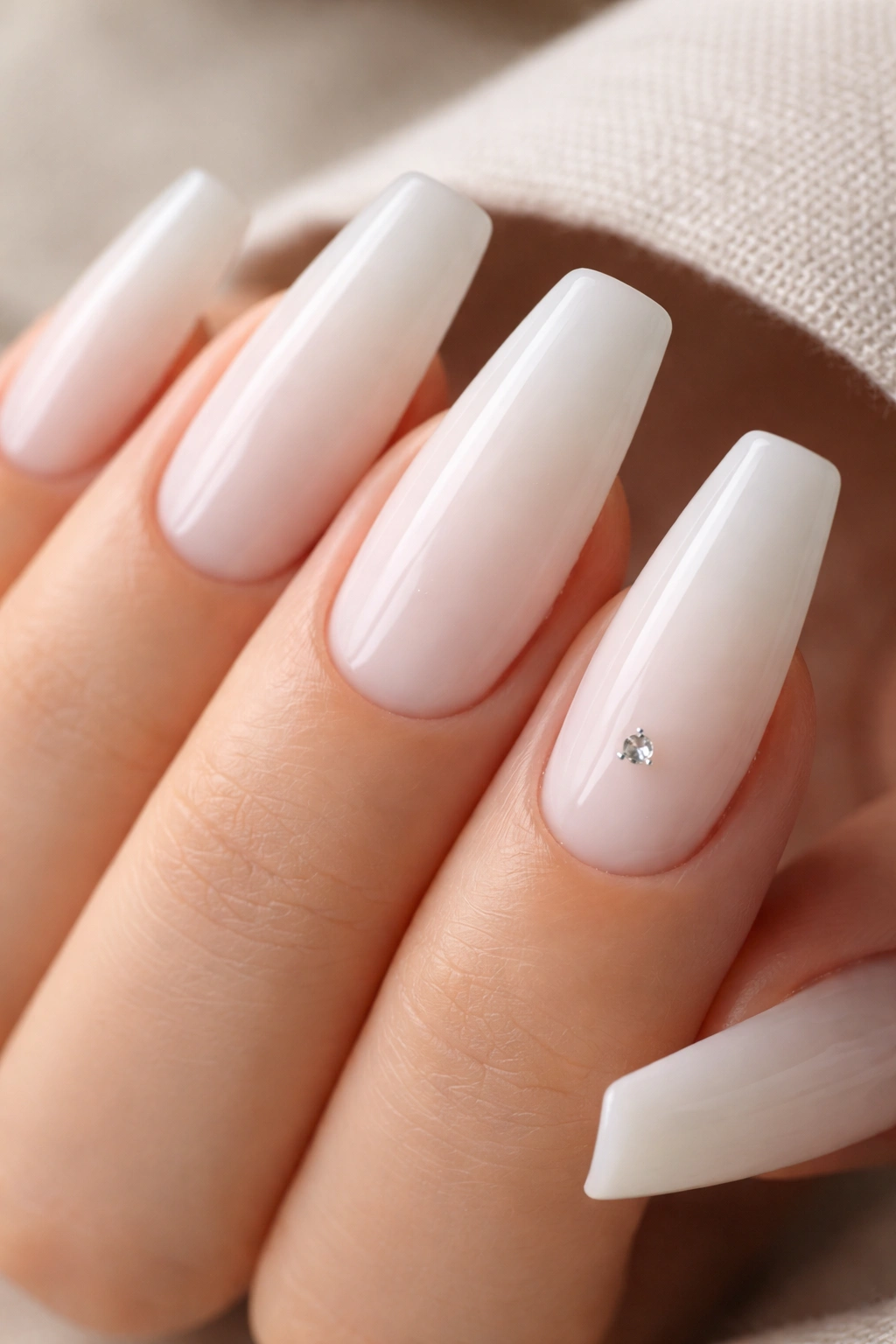 Milky white coffin nails with a single tiny crystal accent