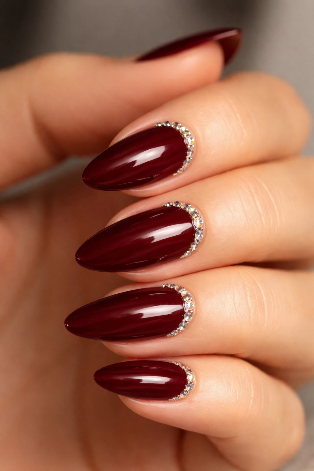 Almond nails with crystal line at cuticle on dark red polish