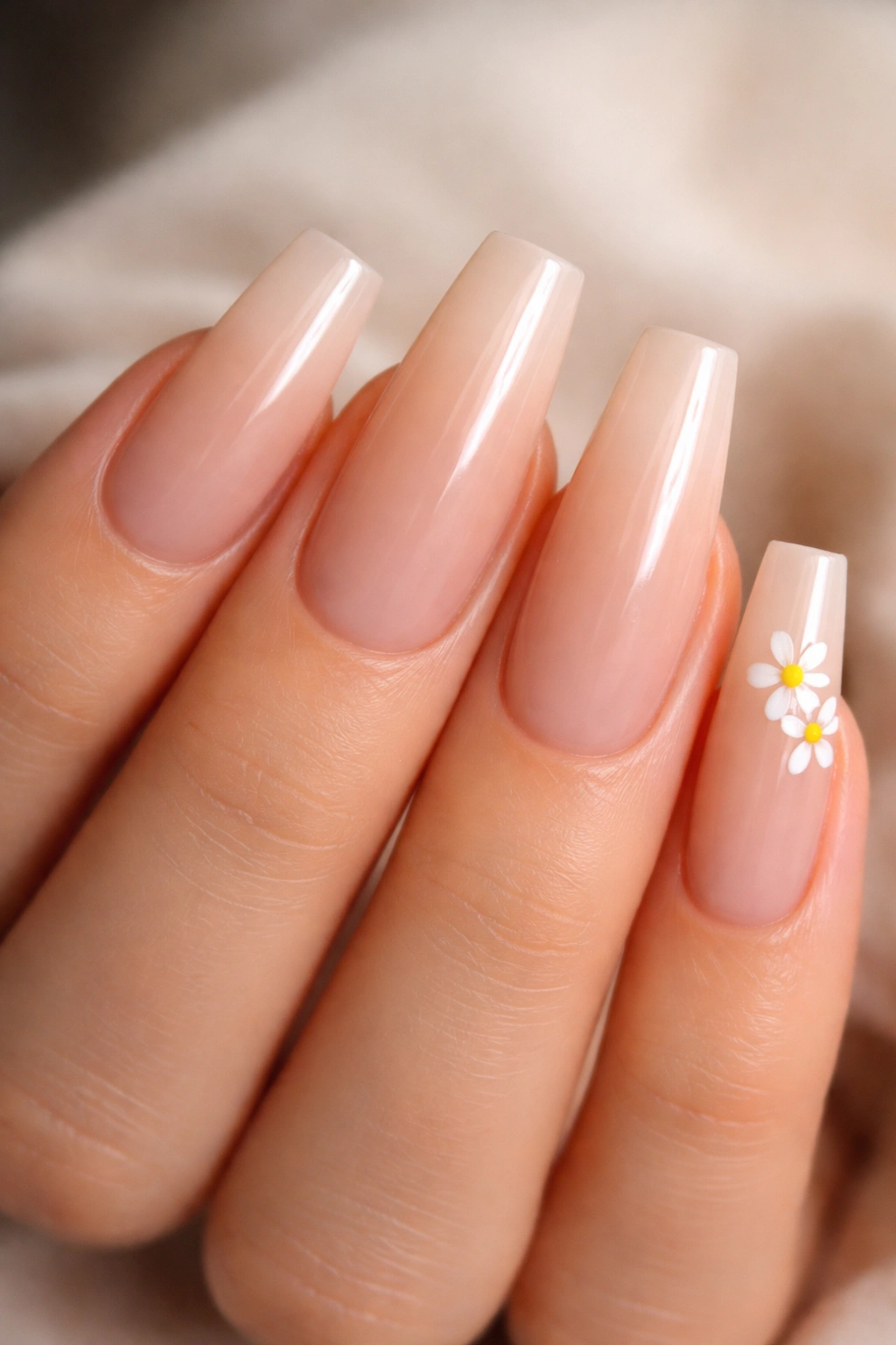 Coffin nails with nude base and small white daisies at the corner