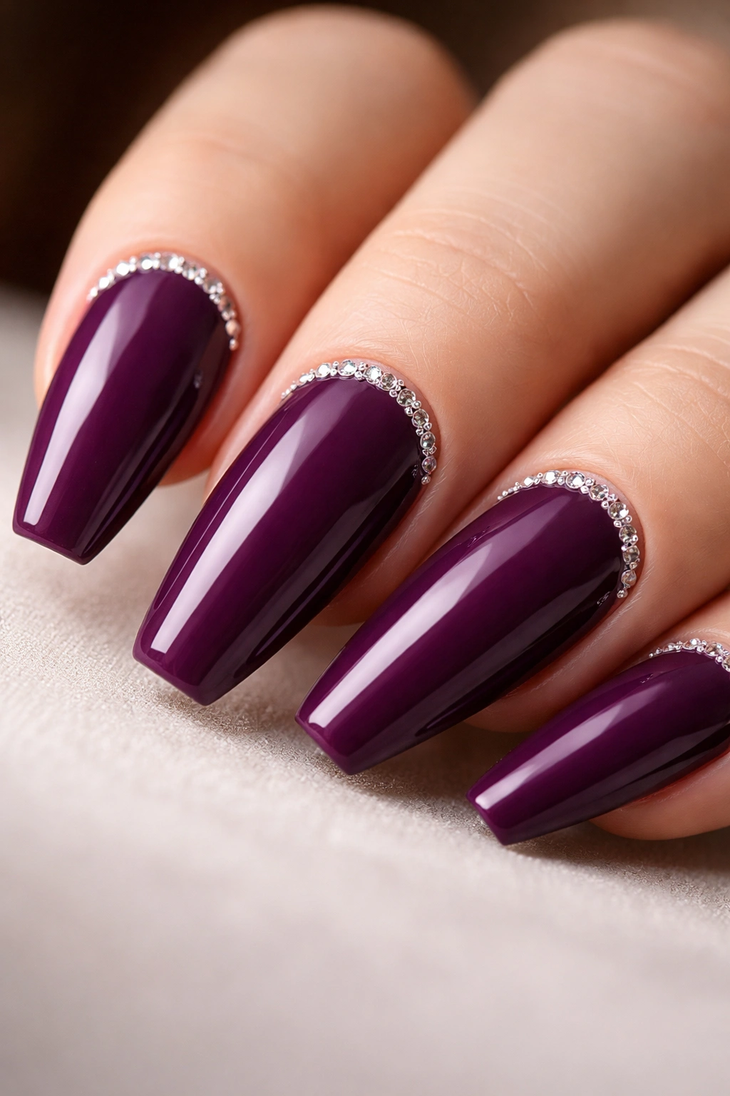 Close-up of dark orchid nail with fine crystal cuticle line