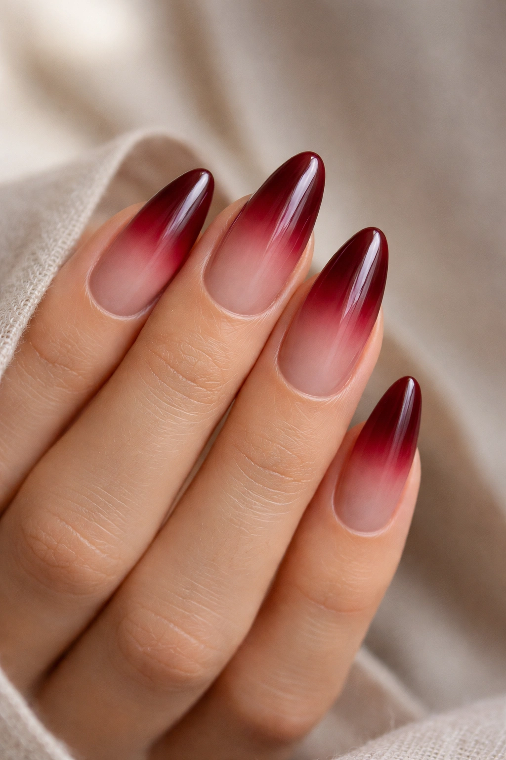Almond nails with deep cherry ombré fade from sheer to red