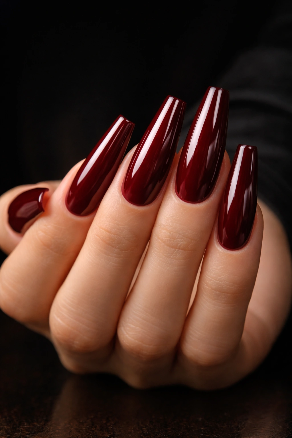 Deep red coffin nails with wet-look shine on hand