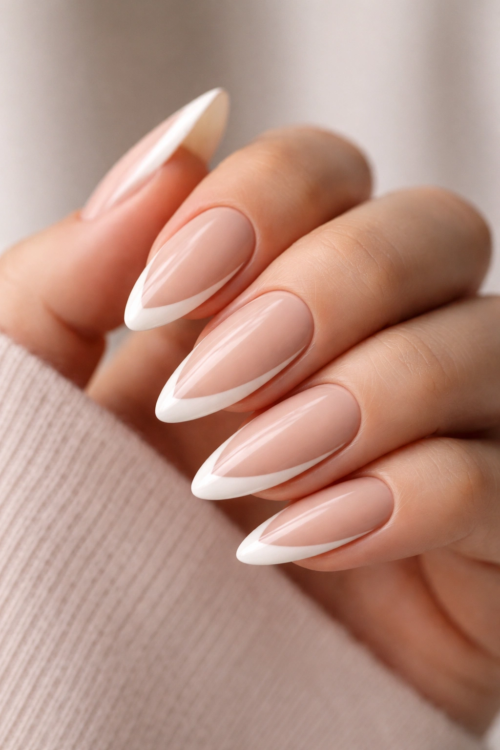 Almond nails with a deep side French nude design on beige base