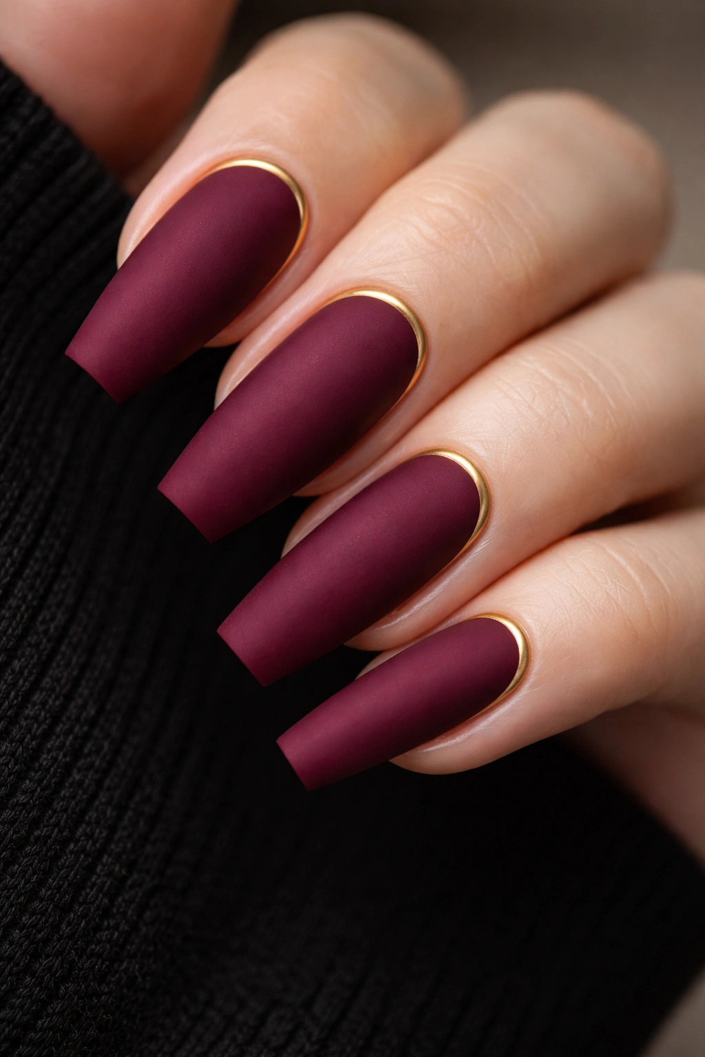 Deep wine matte nails with thin gold cuticle lines