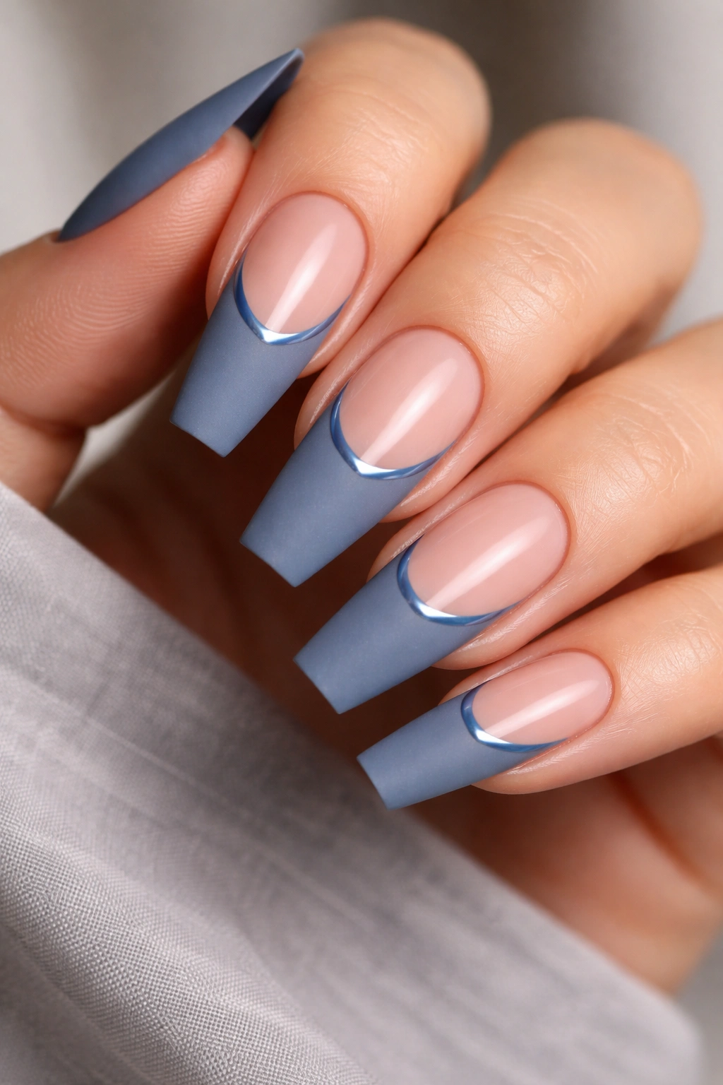 Close-up of denim blue matte French nails with a glossy smile line.
