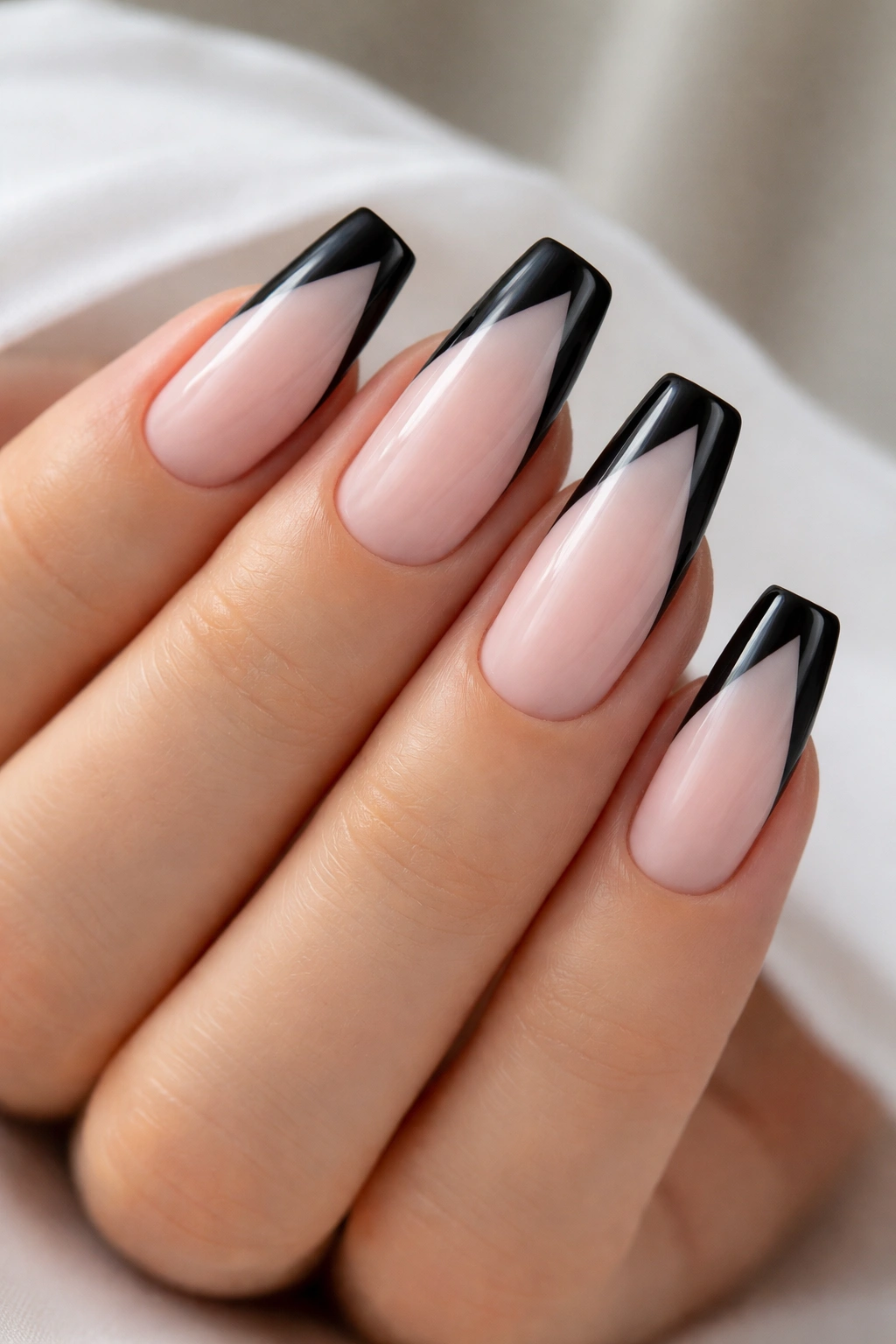 Coffin nails with diagonal black French tips on milky pink base