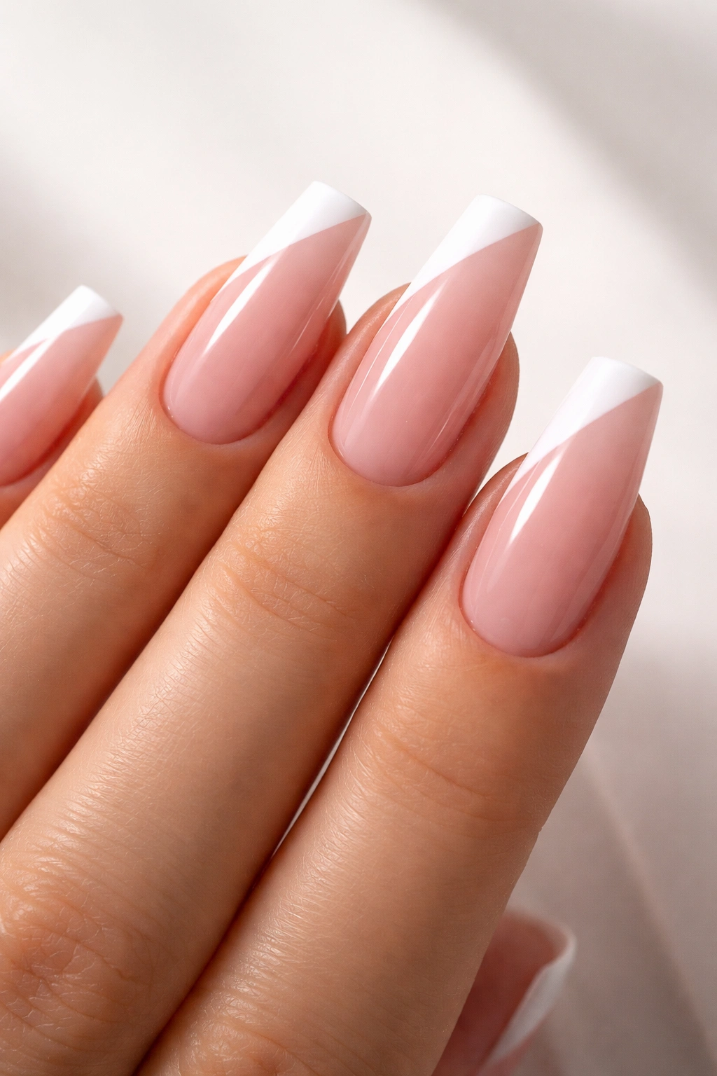 Close-up of diagonal side French on sheer pink coffin nails