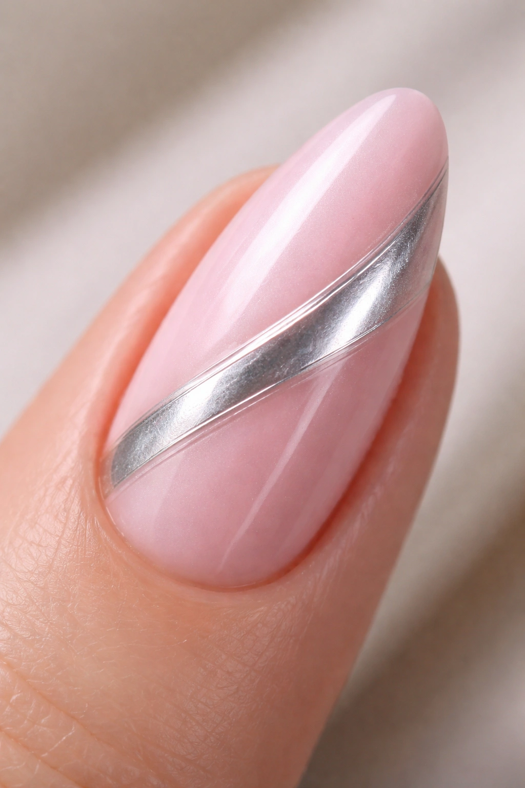 Almond nail with diagonal chrome swoosh across pink chrome.